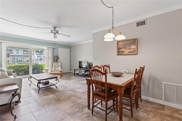 dining area with crown molding and ceiling fan with notable chandelier