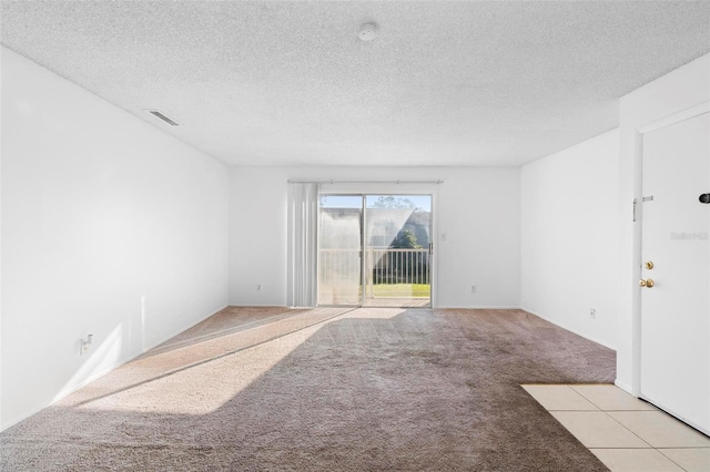 carpeted empty room with a textured ceiling