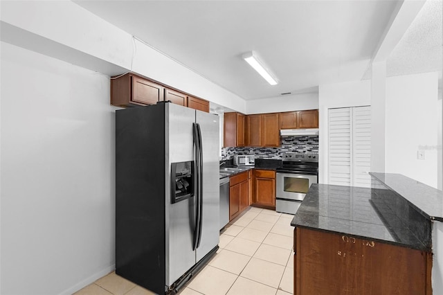 kitchen with stainless steel appliances, light tile patterned floors, and tasteful backsplash