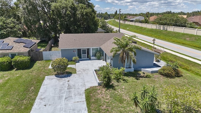 view of front facade featuring solar panels and a front yard