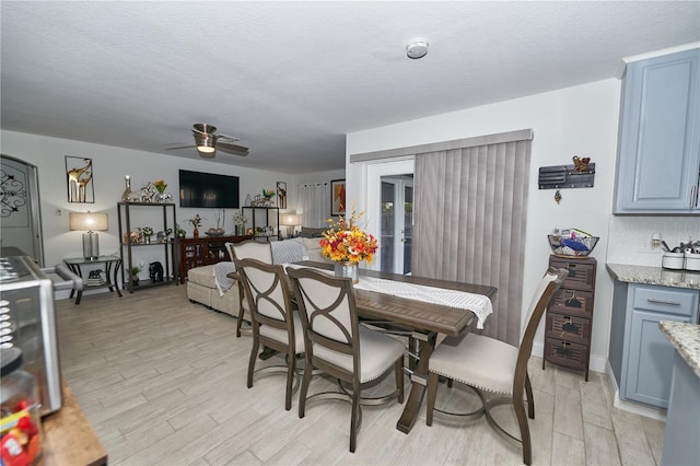 dining room featuring light hardwood / wood-style floors, a textured ceiling, and ceiling fan