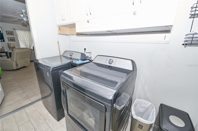 laundry area featuring light wood-type flooring, washing machine and dryer, cabinets, and ceiling fan