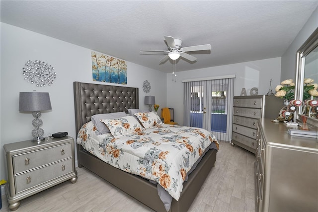 bedroom with light hardwood / wood-style floors, a textured ceiling, access to exterior, and ceiling fan