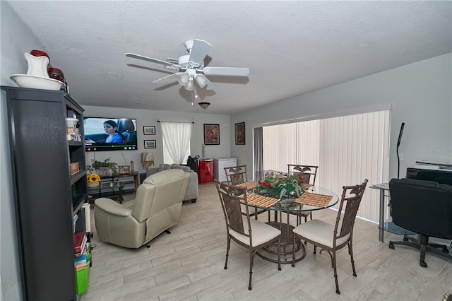 dining area featuring a textured ceiling, light wood-type flooring, and ceiling fan