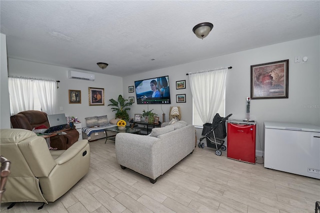 living room with a wall mounted air conditioner and a textured ceiling