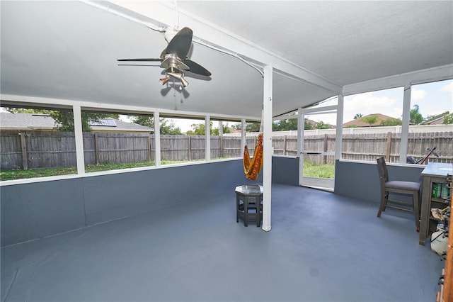 unfurnished sunroom with ceiling fan