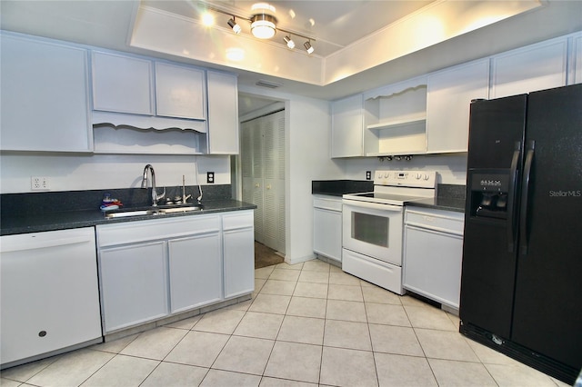 kitchen with sink, white cabinets, light tile patterned floors, a tray ceiling, and white appliances