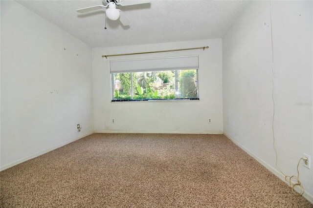 unfurnished room featuring baseboards, carpet floors, a textured ceiling, and a ceiling fan