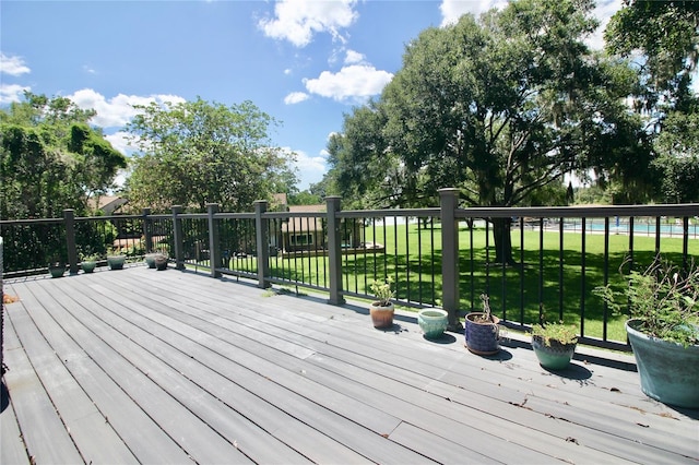 wooden deck featuring a lawn