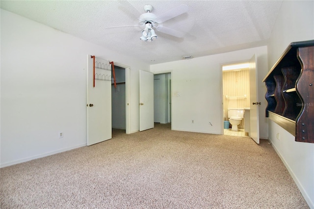 unfurnished bedroom with visible vents, a textured ceiling, connected bathroom, carpet floors, and baseboards