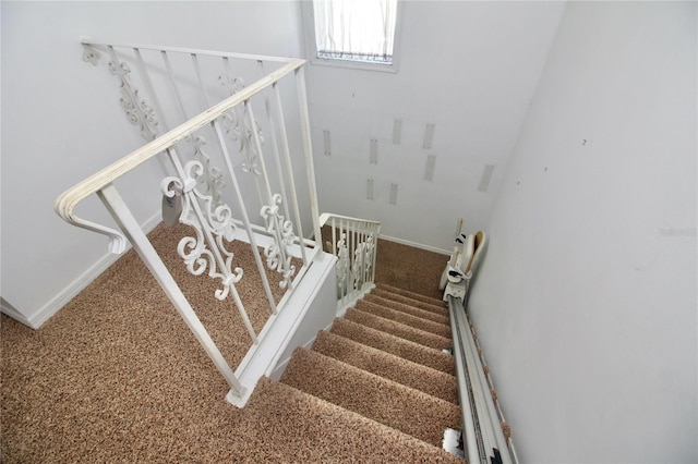 staircase with baseboards and carpet floors