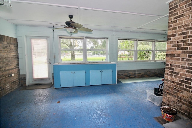 unfurnished sunroom with a ceiling fan