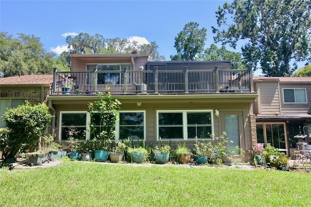 back of house with a balcony and a yard