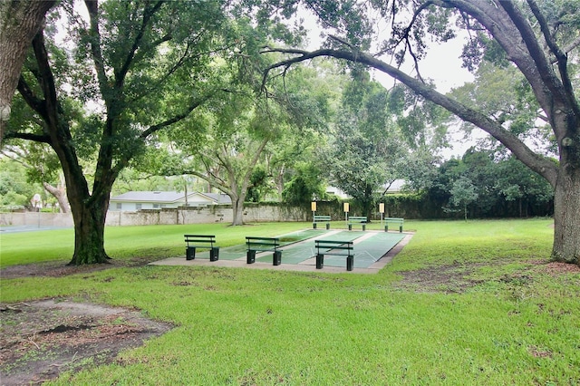 surrounding community with shuffleboard and a lawn