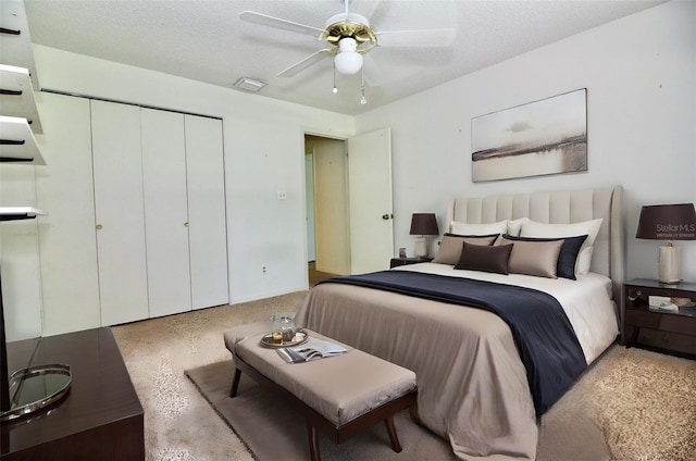 bedroom with a closet, visible vents, a textured ceiling, and a ceiling fan