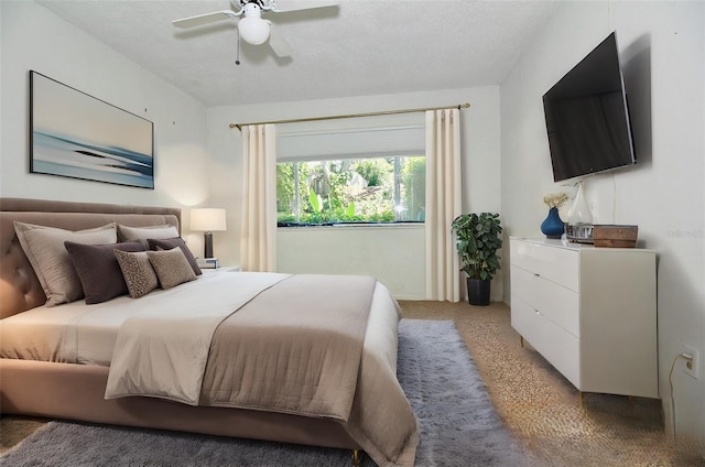 bedroom featuring light carpet, a textured ceiling, and a ceiling fan