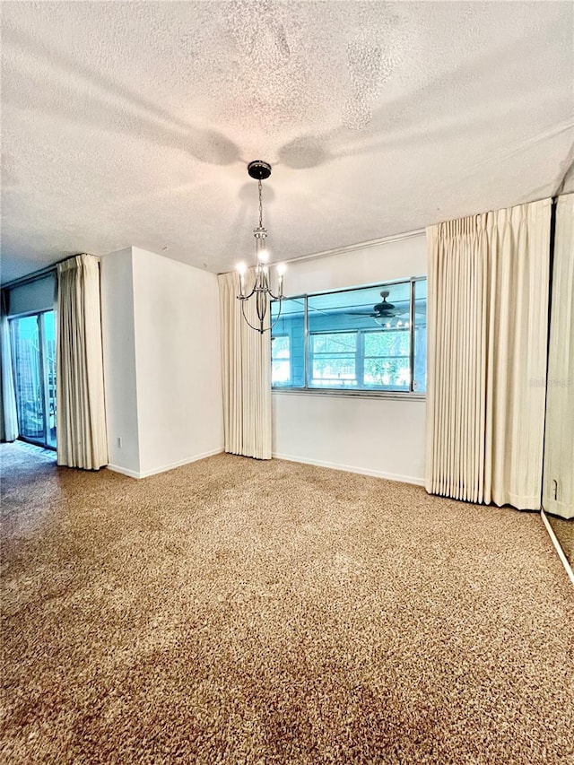 carpeted spare room featuring a chandelier, a textured ceiling, and baseboards