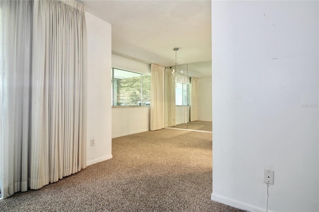 carpeted spare room with baseboards