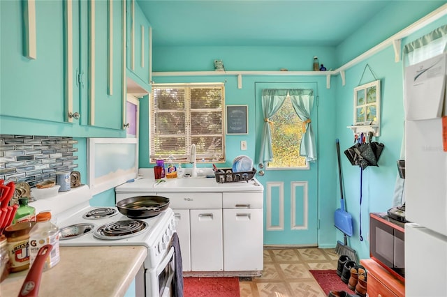 kitchen with a sink, light countertops, backsplash, white range with electric stovetop, and light floors