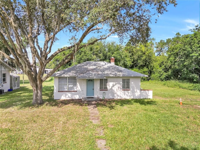 view of front of home with a chimney and a front yard