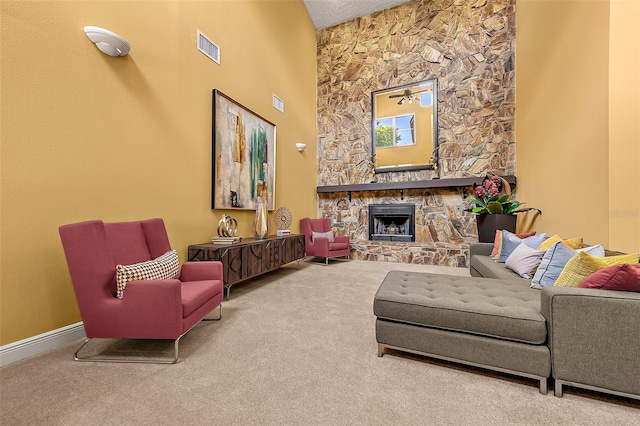 carpeted living room featuring a stone fireplace