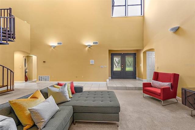 interior space with french doors, a towering ceiling, and light tile patterned flooring