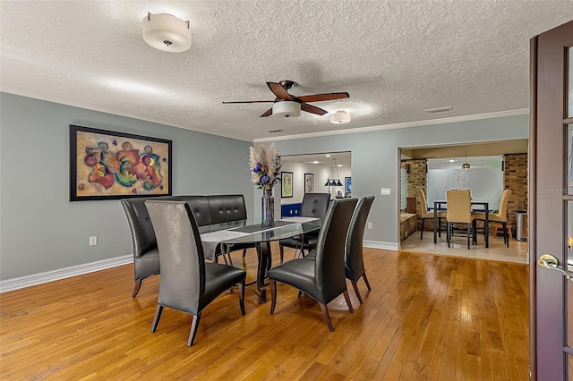 dining area featuring ceiling fan, ornamental molding, hardwood / wood-style floors, and a textured ceiling