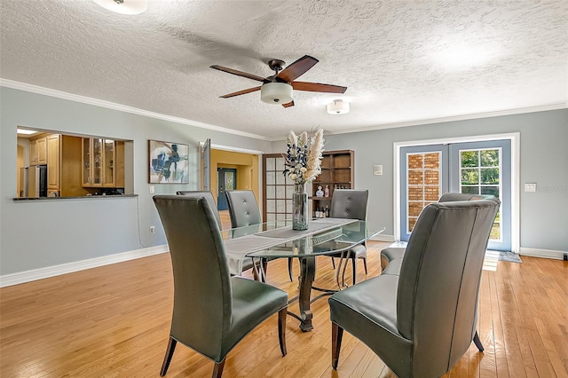 dining room with light hardwood / wood-style flooring, ornamental molding, french doors, and ceiling fan