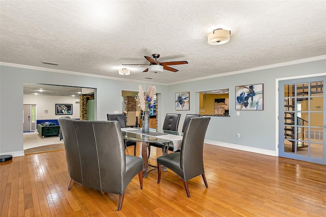 dining room with crown molding, ceiling fan, and light wood-type flooring