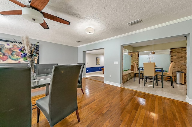 interior space featuring crown molding, ceiling fan, a textured ceiling, and light wood-type flooring