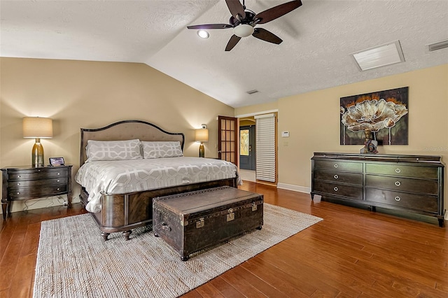 bedroom featuring vaulted ceiling, hardwood / wood-style floors, and a textured ceiling