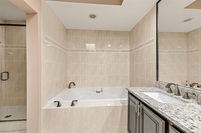 bathroom with plus walk in shower, tile walls, and vanity