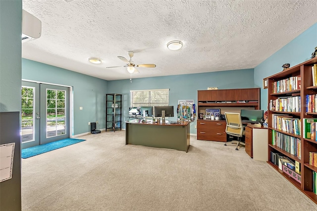 office space with ceiling fan, a textured ceiling, french doors, light colored carpet, and an AC wall unit