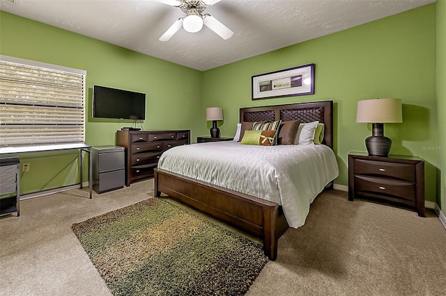 carpeted bedroom featuring ceiling fan and a textured ceiling