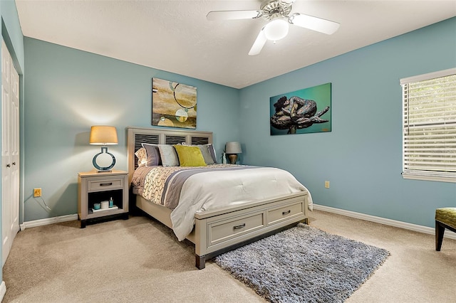 bedroom with light colored carpet, a textured ceiling, and ceiling fan