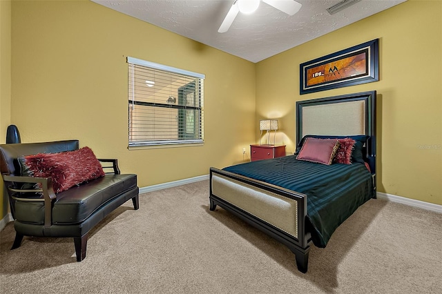 carpeted bedroom featuring ceiling fan and a textured ceiling