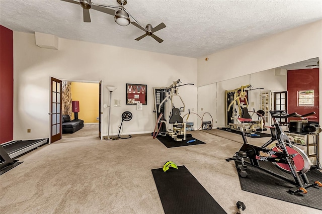 workout room with ceiling fan, carpet floors, french doors, and a textured ceiling