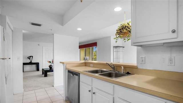 kitchen with white cabinetry, white fridge, stainless steel dishwasher, sink, and light colored carpet