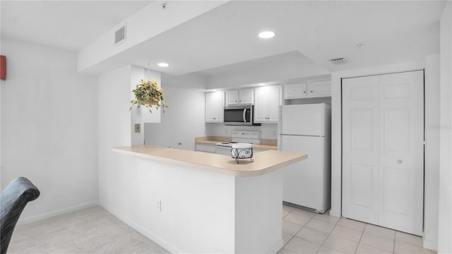 kitchen featuring white cabinets, white appliances, kitchen peninsula, and light tile patterned floors