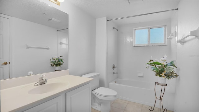 full bathroom with a textured ceiling, tiled shower / bath, tile patterned flooring, vanity, and toilet