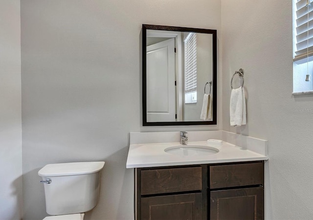 bathroom with vanity, toilet, and a wealth of natural light