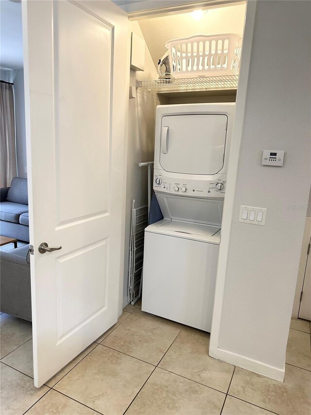 washroom with light tile patterned floors and stacked washer and clothes dryer