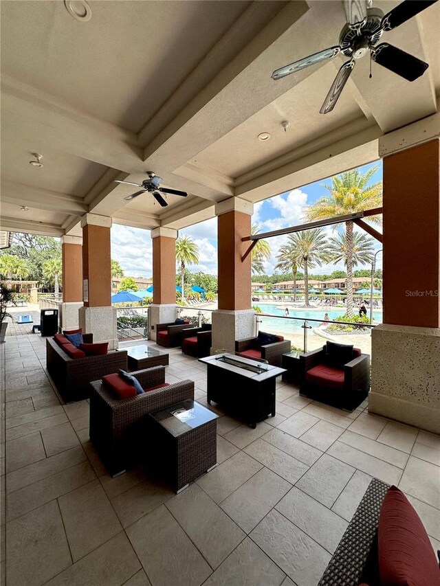 view of patio with ceiling fan and an outdoor living space with a fire pit