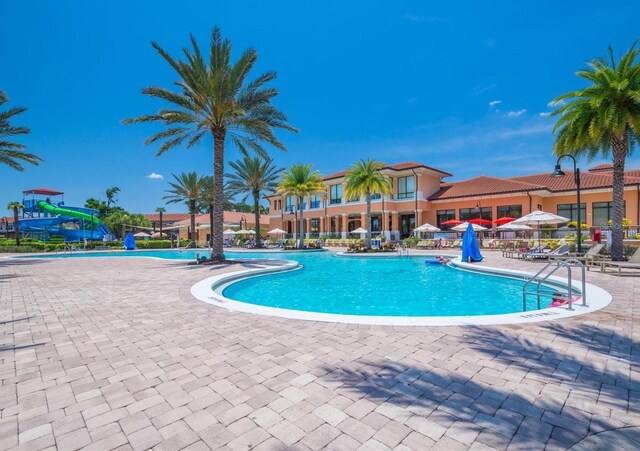 view of swimming pool with a patio area and a water slide