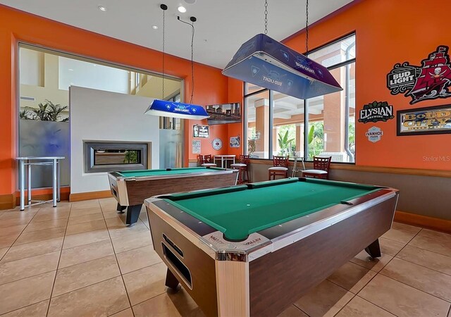 recreation room featuring a fireplace, light tile patterned floors, and pool table