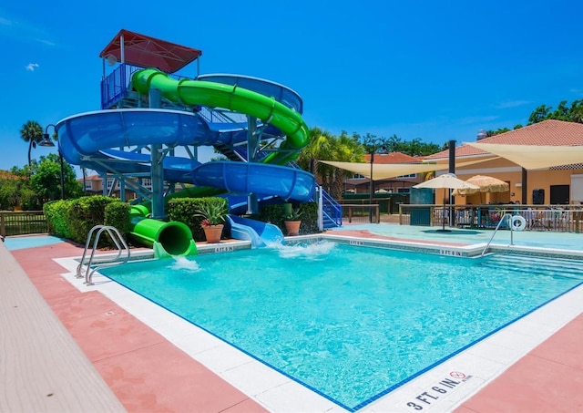 view of pool featuring a patio area and a water slide