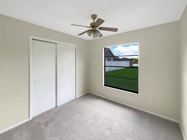 unfurnished bedroom featuring ceiling fan, a closet, and carpet