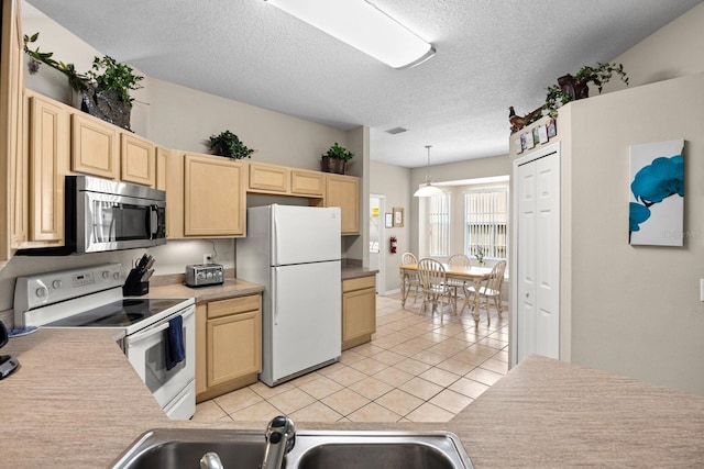 kitchen with sink, stainless steel appliances, decorative light fixtures, light brown cabinetry, and light tile patterned floors