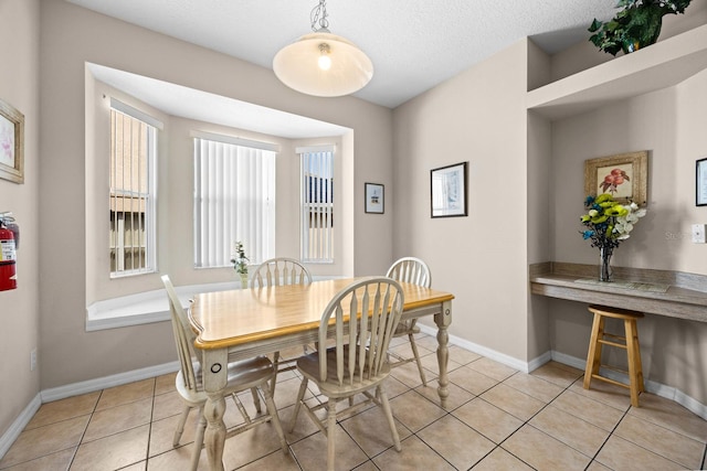 dining area featuring light tile patterned floors and a textured ceiling