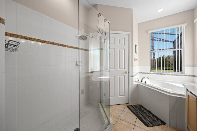 bathroom with tile patterned flooring, a textured ceiling, and independent shower and bath